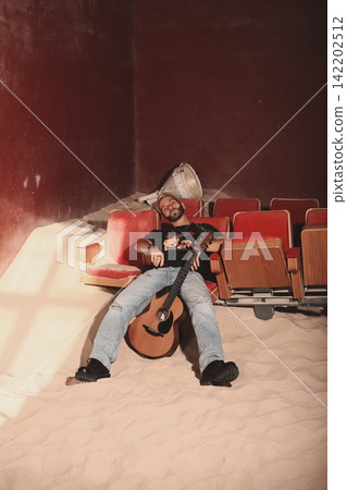 Chilled performer lounging with guitar amid warm daylight shadows Chilled performer lounging with guitar amid warm daylight shadows 142202512