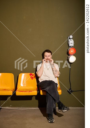 Relaxed individual taking pause with snack amid city transit environment Relaxed individual taking pause with snack amid city transit environment 142202612