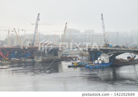 Bridge span assembly with cranes and barges in channel Bridge span assembly with cranes and barges in channel 142202689