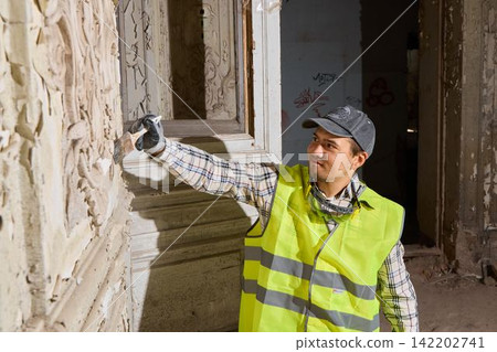 Conservator carefully removes grime from historic wall surface Conservator carefully removes grime from historic wall surface 142202741