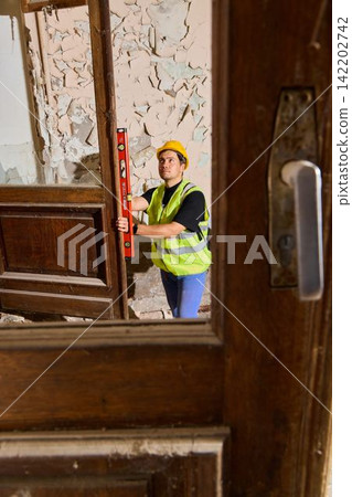 Field technician assesses wall straightness with handheld device Field technician assesses wall straightness with handheld device 142202742