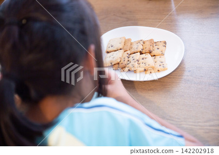 一個孩子正在吃自製的米粉巧克力曲奇餅乾。 一個孩子正在吃自製的米粉巧克力曲奇餅乾。 142202918