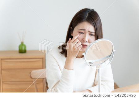 一位女士因眼疾正在照鏡子。 142203450