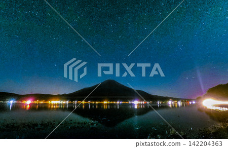 Mount Fuji Silhouette Under a Vast Milky Way and Reflecting Lake Mount Fuji Silhouette Under a Vast Milky Way and Reflecting Lake 142204363