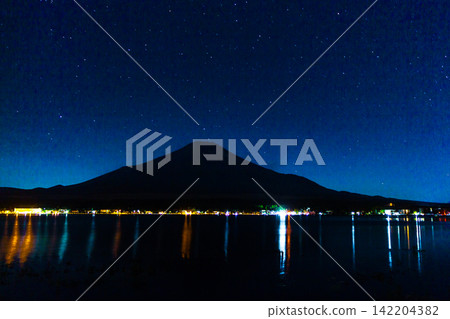 Mount Fuji Silhouette Beneath a Broad Starry Sky With Lakeside Reflections Mount Fuji Silhouette Beneath a Broad Starry Sky With Lakeside Reflections 142204382