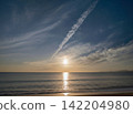The sea at dusk and the setting sun in the background. 142204980