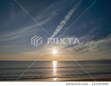 黃昏時的大海,遠處是緩緩落下的太陽。 黃昏時的大海,遠處是緩緩落下的太陽。 142204980