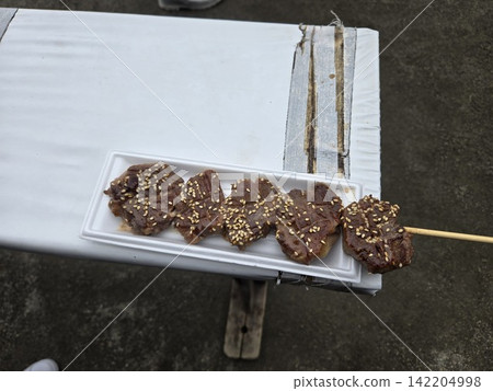 街邊小攤和食品攤販提供的美味烤牛肉串和各種肉類菜餚的圖片。 街邊小攤和食品攤販提供的美味烤牛肉串和各種肉類菜餚的圖片。 142204998