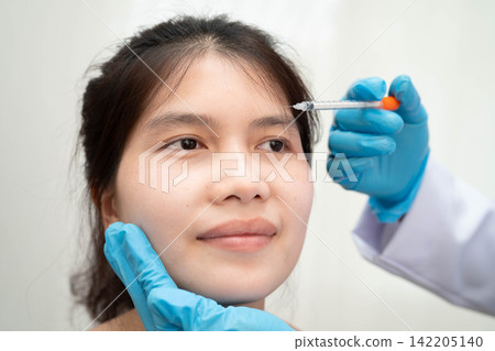 Asian woman receiving plastic surgery shape of nose performed on face. Asian woman receiving plastic surgery shape of nose performed on face. 142205140