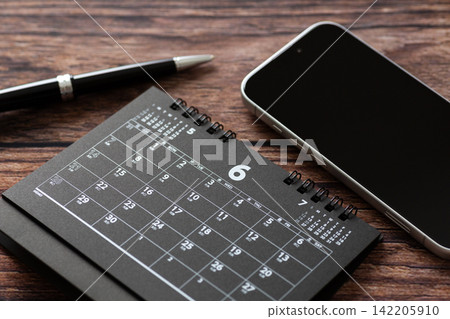 A black calendar and smartphone for June A black calendar and smartphone for June 142205910