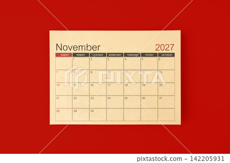 November 2027 desk calendar made from brown paper page on red background. November 2027 desk calendar made from brown paper page on red background. 142205931