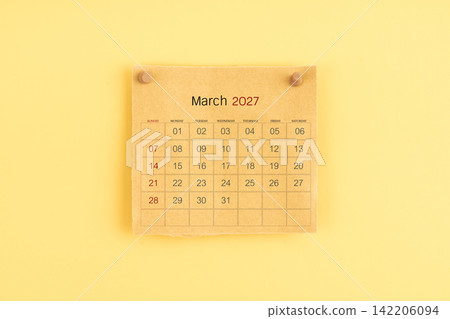 March 2027 brown calendar with wooden thumbtack on yellow background. March 2027 brown calendar with wooden thumbtack on yellow background. 142206094