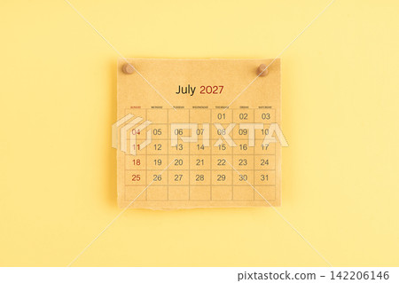 July 2027 brown calendar with wooden thumbtack on yellow background. July 2027 brown calendar with wooden thumbtack on yellow background. 142206146