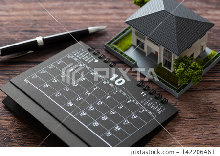 A black calendar for October and a model house A black calendar for October and a model house 142206461