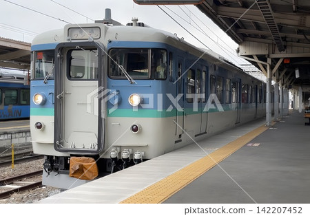 A 115 series train (Shinshu color) local train bound for Karuizawa departing from Komoro Station on the Shinano Railway. A 115 series train (Shinshu color) local train bound for Karuizawa departing from Komoro Station on the Shinano Railway. 142207452
