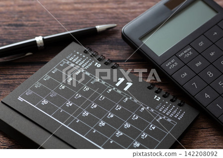 A November calendar and a black calculator A November calendar and a black calculator 142208092