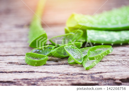 aloe vera plant slice on rustic wood background - close up of fresh aloe vera leaf with gel natural herbs and herbal medicines aloe vera plant slice on rustic wood background - close up of fresh aloe vera leaf with gel natural herbs and herbal medicines 142208756
