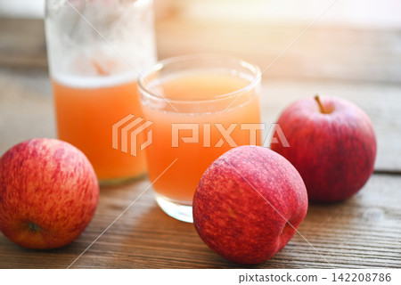 apple cider vinegar natural remedies and cures for common health condition, raw and unfiltered organic apple cider vinegar in glass with apple fruit on the wooden table apple cider vinegar natural remedies and cures for common health condition, raw and unfiltered organic apple cider vinegar in glass with apple fruit on the wooden table 142208786