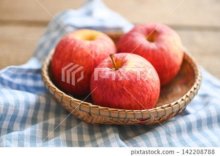 apple fruit on basket on the wooden table, ripe red apples. apple fruit on basket on the wooden table, ripe red apples. 142208788