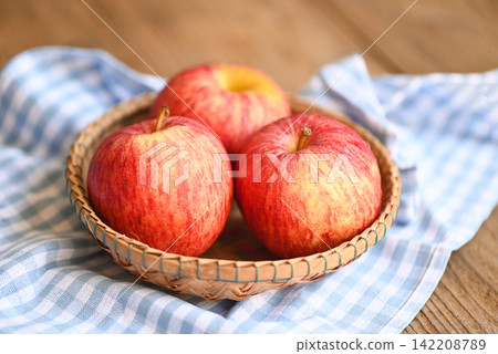 apple fruit on basket on the wooden table, ripe red apples apple fruit on basket on the wooden table, ripe red apples 142208789