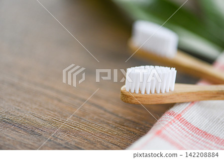 Zero waste Bathroom use less plastic concept - bamboo toothbrush on the fabric eco natural plastic free items and green leaf on rustic background Zero waste Bathroom use less plastic concept - bamboo toothbrush on the fabric eco natural plastic free items and green leaf on rustic background 142208884