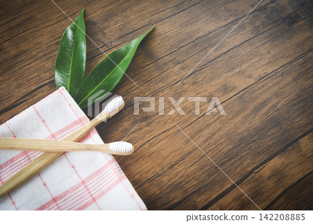 bamboo toothbrush and green leaf on rustic background / Zero waste Bathroom use less plastic bamboo toothbrush and green leaf on rustic background / Zero waste Bathroom use less plastic 142208885