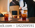 咖啡館裡有人在消磨時間，桌上放著兩杯飲料。 142209591