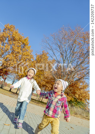 Sister and brother playing in the autumn park Sister and brother playing in the autumn park 142209737