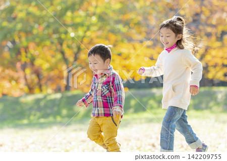 Sister and brother playing in the autumn park Sister and brother playing in the autumn park 142209755
