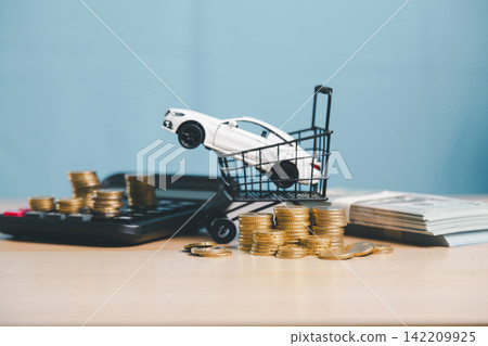 White toy car in shopping basket with calculator, cash, and coin stacks, representing car purchase price, auto loan, vehicle finance, payment plan, and buying decision. White toy car in shopping basket with calculator, cash, and coin stacks, representing car purchase price, auto loan, vehicle finance, payment plan, and buying decision. 142209925