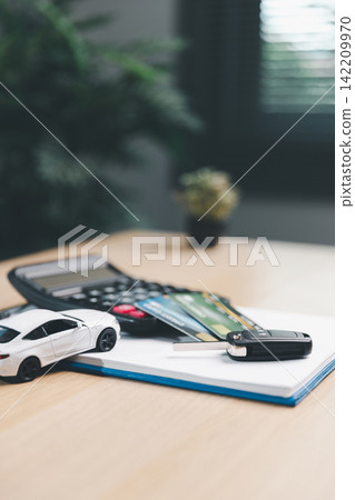 Miniature car, car key, credit cards, calculator, and notebook on desk, illustrating car loan approval, credit payment, insurance, and financial planning for vehicle ownership. Miniature car, car key, credit cards, calculator, and notebook on desk, illustrating car loan approval, credit payment, insurance, and financial planning for vehicle ownership. 142209970