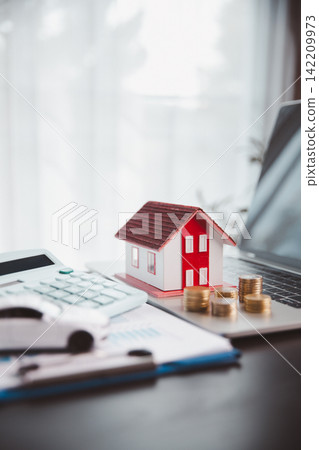 House model on a laptop beside calculator, coins, documents, and car represents digital mortgage planning, online budgeting, property finance, vehicle costs, and household asset management. House model on a laptop beside calculator, coins, documents, and car represents digital mortgage planning, online budgeting, property finance, vehicle costs, and household asset management. 142209973