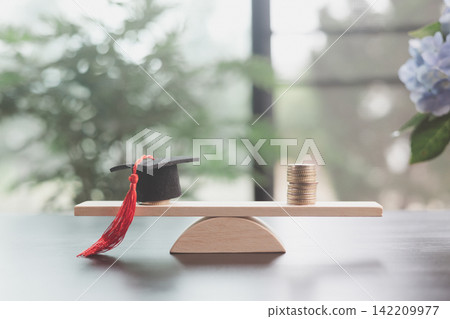 Graduation cap and stacked coins balance on a wooden scale, representing education cost, tuition value, financial decisions, affordability, investment, and equal learning opportunity. Graduation cap and stacked coins balance on a wooden scale, representing education cost, tuition value, financial decisions, affordability, investment, and equal learning opportunity. 142209977