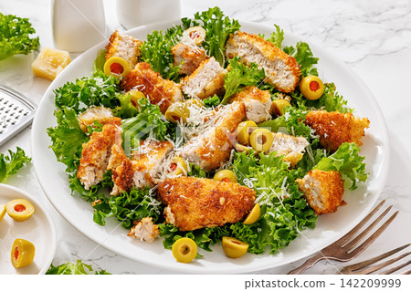 Sliced breaded pork cutlet salad on a plate 142209999
