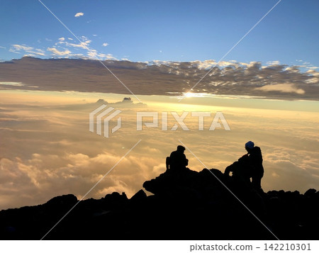 登山者站在山頂，凝視著雲海和日出，他們的身影在山巒間若隱若現。 142210301