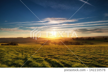 Sunrise Landscape Over Green Countryside Fields and Rolling Hills Sunrise Landscape Over Green Countryside Fields and Rolling Hills 142210578