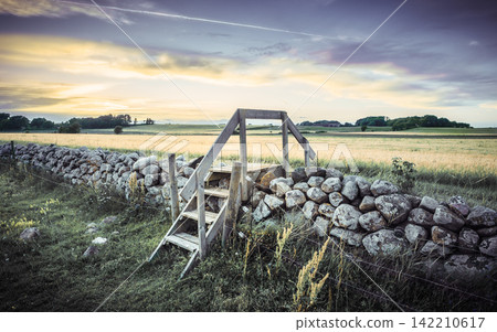 Rural Landscape with Stone Wall and Wooden Stile at Sunset 142210617