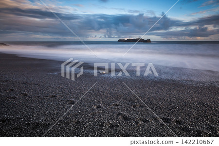 Stormy Ocean Seascape with Black Pebble Beach and Long Exposure Waves Stormy Ocean Seascape with Black Pebble Beach and Long Exposure Waves 142210667