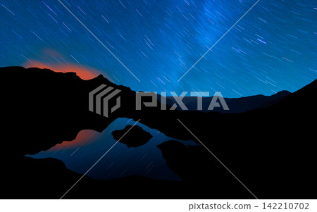 Star Trails Over Mountain Lake at Night Star Trails Over Mountain Lake at Night 142210702