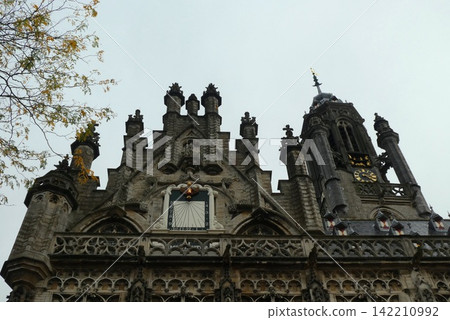 Gothic Clock Tower on Historic Stone Building Facade 142210992
