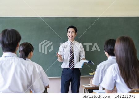 Male teacher teaching in a classroom Male teacher teaching in a classroom 142211075