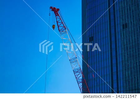 A crane at a construction site in an urban area [Construction image] 142211547