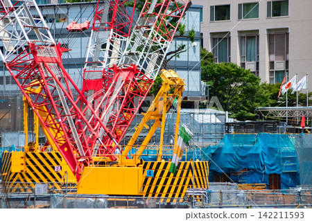 A crane at a construction site in an urban area [Construction image] 142211593