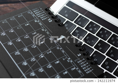A black calendar and a computer for January A black calendar and a computer for January 142211974