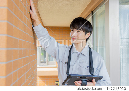 一名男子正在檢查外牆。 142212020