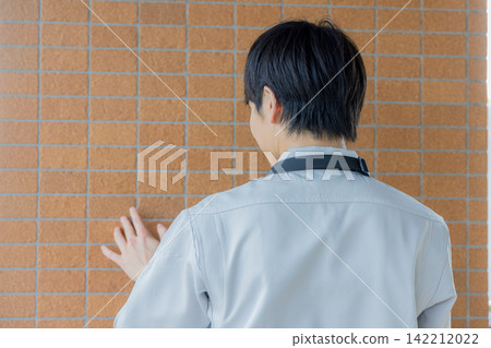 A man inspecting the exterior walls. A man inspecting the exterior walls. 142212022