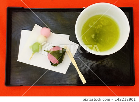A set of Japanese sweets for cherry blossom viewing (three-colored dango and sakura mochi) and green tea. 142212901