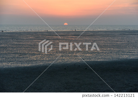 A serene sunset over a vast, tranquil beach A serene sunset over a vast, tranquil beach 142213121