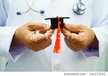 Asian woman doctor holding graduation hat in hospital. 142213541