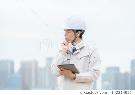 一位身穿工作服的男士正在為房地產問題煩惱。 一位身穿工作服的男士正在為房地產問題煩惱。 142214935